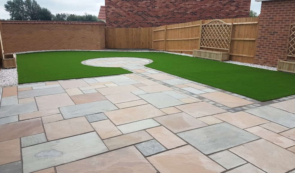 Landscaped with large sandstone patio, artificial grass & border